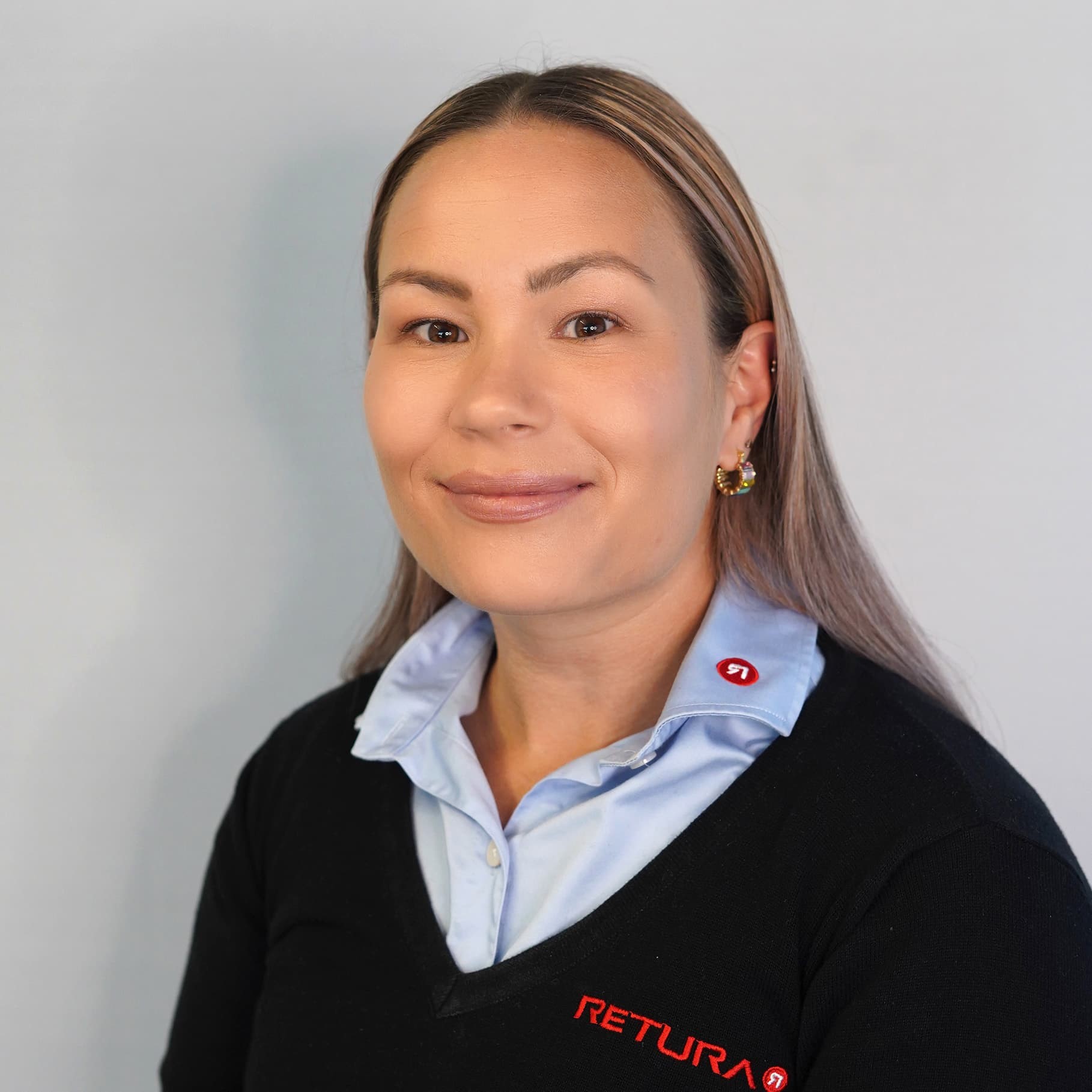 blid dame med langt hår i genser og skjorte